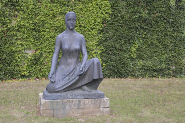 Sculpture Mother Earth by Fritz Cremer 1951, seated female figure, bronze sculpture, life-size, arms, gesture, symbol, religious, philosophical, nature, sculpture park, Magdeburg, Saxony-Anhalt, Germany