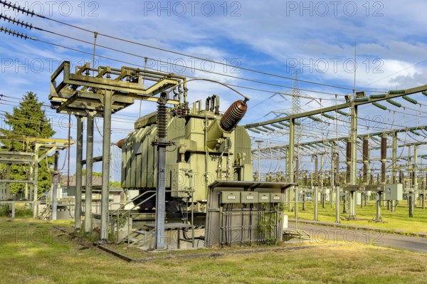 In front large transformer transformer transformer power transformer in transformer station, on the right hanging suspended power lines for transmission of electrical energy power supply, Germany
