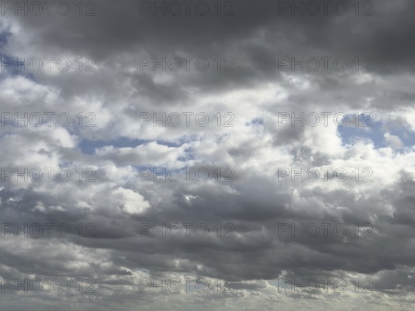 Heavily overcast sky with dark nimbostratus clouds rain clouds at the top and bottom of the picture, stratocumulus clouds in the background above, internationalNimbostratus clouds rain clouds, international