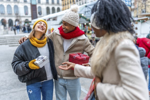 Happy multi ethnic friends joyfully exchanging christmas gifts while enjoying the festive atmosphere of a bustling winter city market