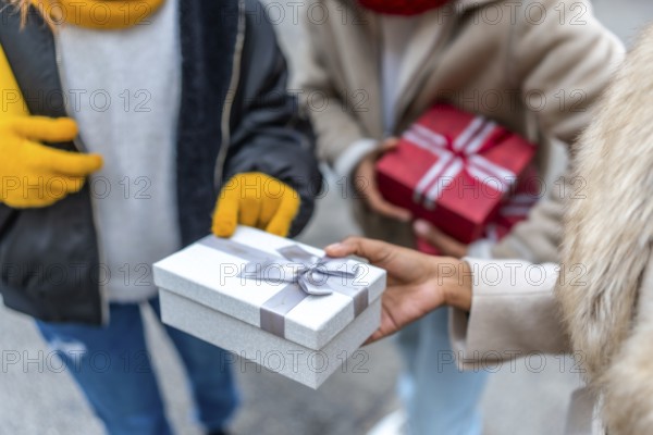 Friends exchanging christmas gifts while enjoying a winter day out in the city, celebrating the joy of the holiday season together