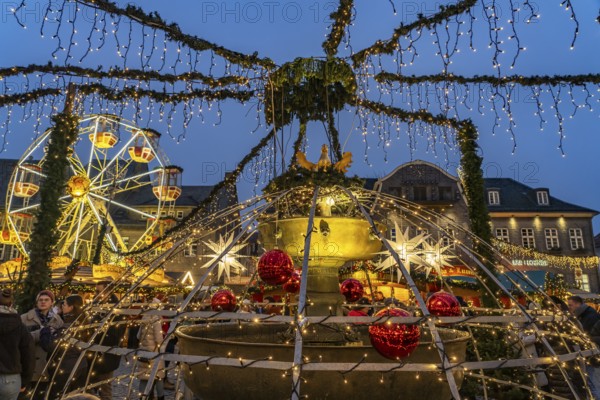 Christmas market at the market fountain in Goslar at dusk, Lower Saxony, Germany