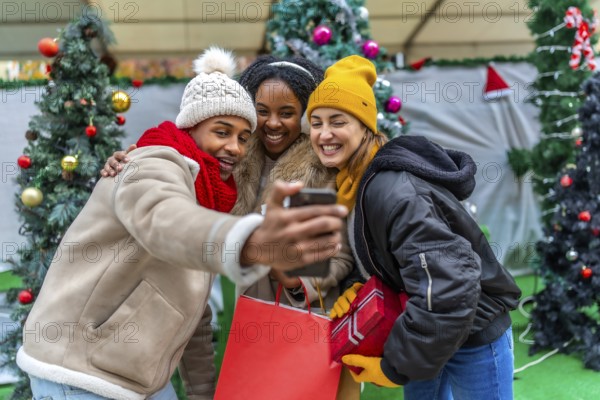 Happy multi ethnic friends enjoying a festive moment while taking a selfie after a day of christmas shopping in a beautifully decorated city