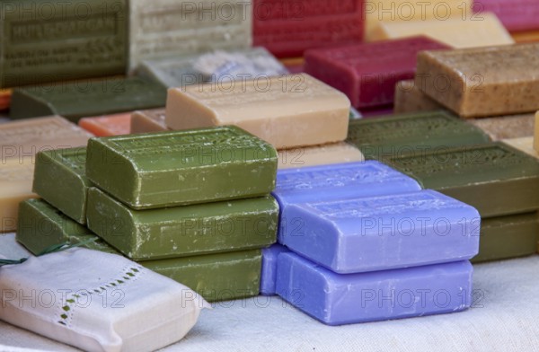 Colourful soap bars in different colours carefully stacked, weekly market market, Tuscany, Italy