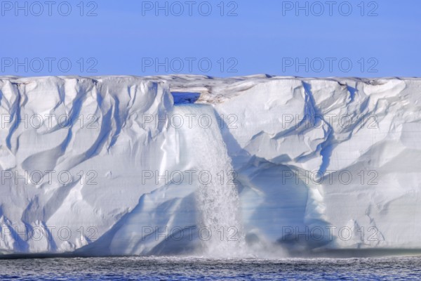 Waterfall at edge of the Brasvellbreen glacier from the ice cap Austfonna debouching into the Barents Sea, Nordaustlandet, Svalbard, Spitsbergen