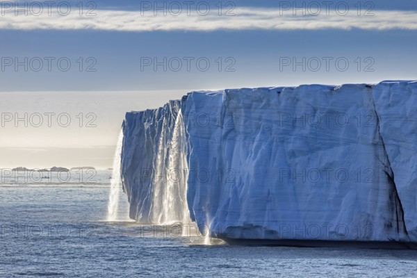 Waterfall at edge of Brasvellbreen glacier from the ice cap Austfonna pouring fresh water into the Barents Sea, Nordaustlandet, Svalbard, Spitsbergen