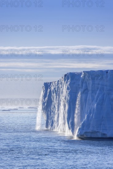 Waterfall at edge of Brasvellbreen glacier from the ice cap Austfonna pouring fresh water into the Barents Sea, Nordaustlandet, Svalbard, Spitsbergen