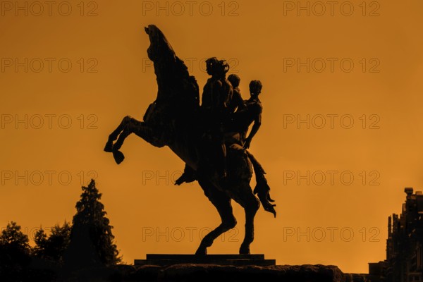 Silhouette of bronze statue of the Ros Beiaard by sculptor Jan Desmarets, folkloristic horse in the city Dendermonde at sunset, East Flanders, Belgium. Digitally manipulated