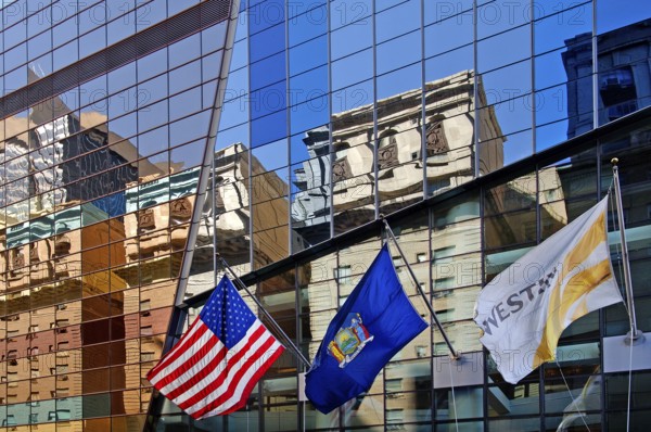 Skyscraper façade with flags and reflection in the glass façade, New York City, USA