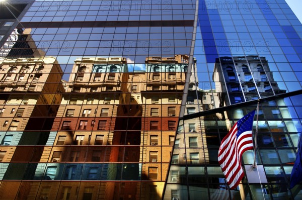 Reflection in the glass facade and with the flag of the USA, New York City, USA