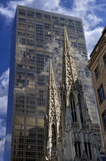 Towers of St Patrick's Cathedral in front of a skyscraper, New York City, USA