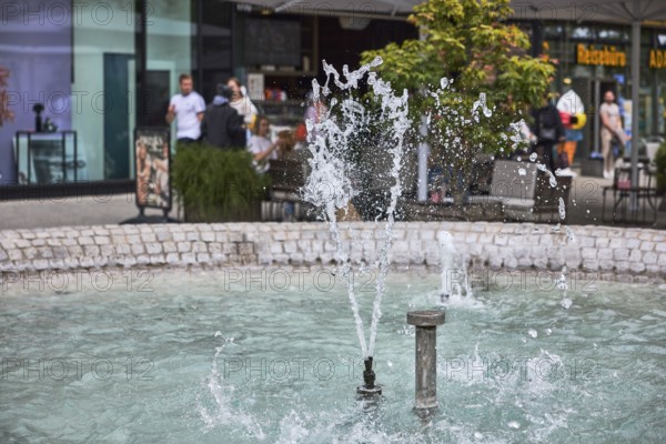 Cobblestone fountain, fountain, water, frozen movement, general architecture, pedestrian zone, shop window, outdoor area of a restaurant, pedestrians as accessories, depth of field, Kronprinzstraße, Büchsenstraße, Stuttgart, state capital, city district of Stuttgart, Baden-Württemberg, Germany