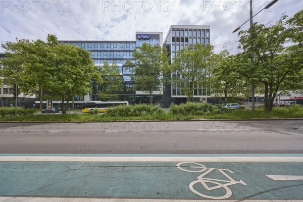 Auditing and management consultancy KPMG, modern architecture, street, public bus, cycle path, coloured lane markings, trees, milky blue sky, diffuse light, slightly sunny, Theodor-Heuss-Straße, Stuttgart, state capital, urban district of Stuttgart, Baden-Württemberg, Germany