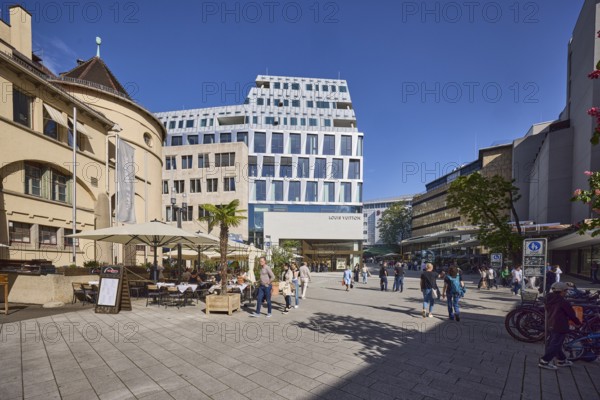Market hall, historical building, shopping, outdoor area with tables, chairs and parasols, restaurant, general architecture, modern buildings, pedestrians as accessories, blue sky, cloudless, intersection Münzstraße with Sporerstraße, Stuttgart, state capital, urban district Stuttgart, Baden-Württemberg, Germany