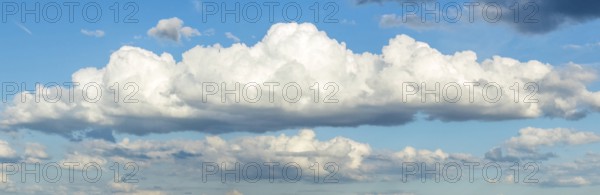 Panoramic photo of long white stratocumulus cloud, in the background more cumulus clouds, international