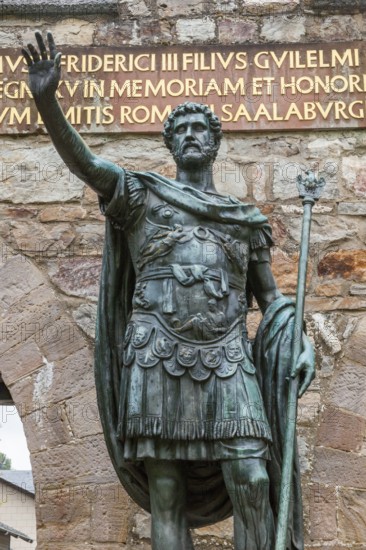 Close-up statue of ancient Roman emperor Antoninus Pius, right arm raised to Roman salute Saluto romano, in front of main portal entrance to reconstructed Roman fort Saalburg, Bad Homburg, Hesse, Germany