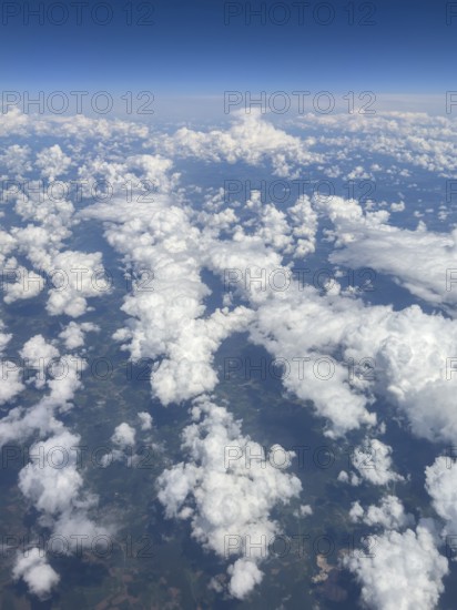Aerial view from aeroplane at high altitude of white, bright cluster clouds Altocumulus, international