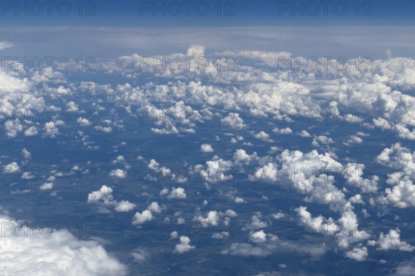 Aerial view from an aeroplane at high altitude of many white, bright cluster clouds Altocumulus, international