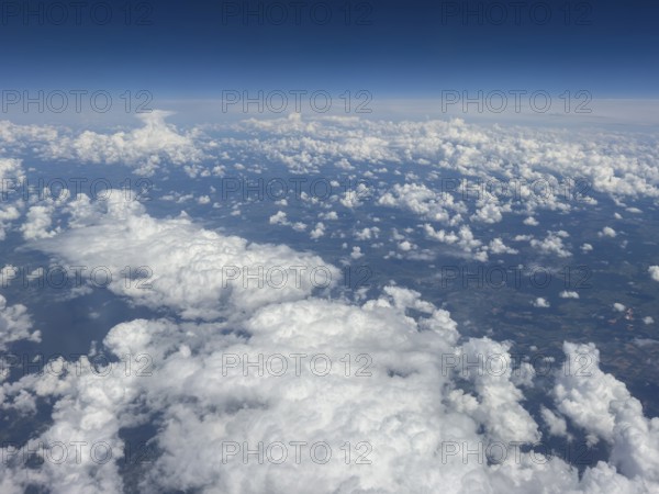 Aerial view from aeroplane at high altitude of white, bright cluster clouds Altocumulus, international