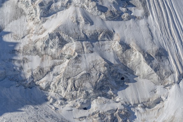 Intricate patterns of ice and rock are showcased in this stunning glacial landscape, revealing the effects of time on the frozen surface. The bright daylight emphasises the textures and colours. Gorner Glacier, Zermatt, Valais, Alps, Swiss