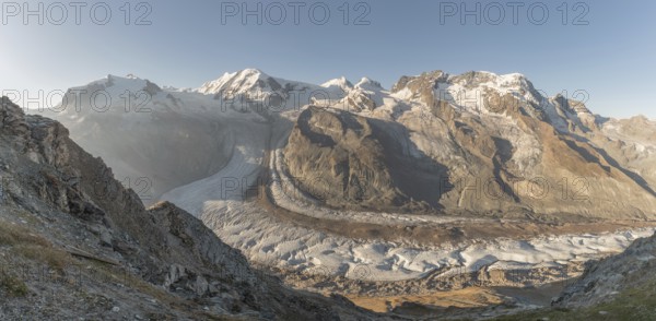 At dawn, the sun bathes the peaks of the Alps in a golden light and reveals stunning glaciers and rocky slopes. The tranquil atmosphere enhances the beauty of this natural wonder. Gorner Glacier, Zermatt, Valais, Alps, Swiss