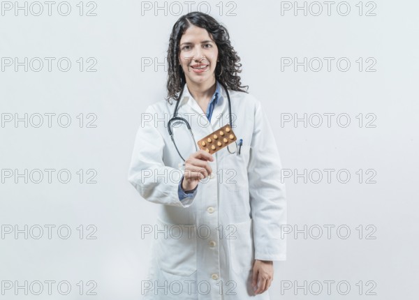 Female doctor holding pills tablet isolated. Portrait of a young female doctor showing pills tablet on isolated background