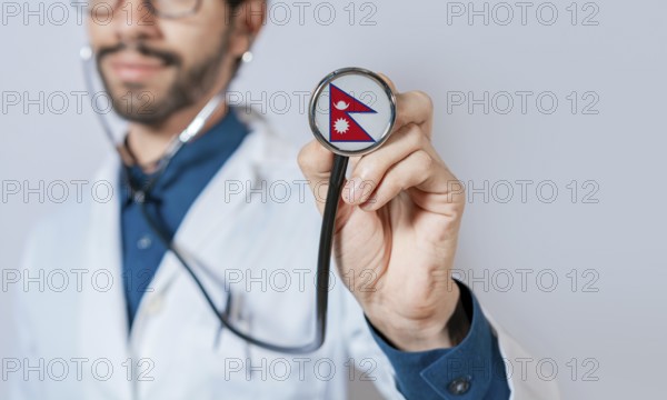 Doctor holding stethoscope with Nepal flag. Nepal health and care concept, Nepal flag on stethoscope