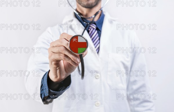 Oman healthcare system, doctor holding stethoscope. Oman health and medical insurance concept
