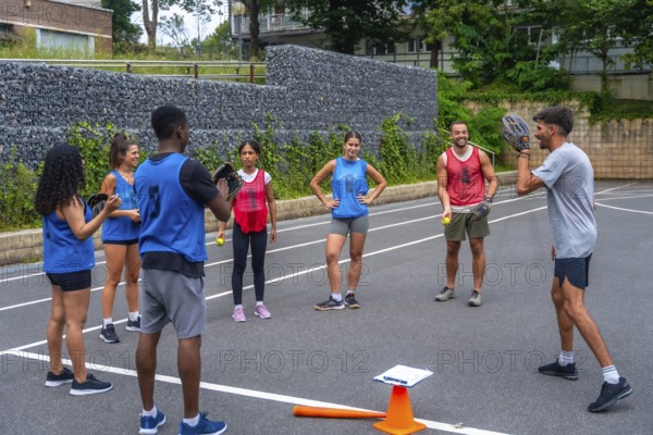 Baseball coach explaining game strategy to team players during training on an outdoor court, promoting teamwork, sportsmanship, and skill development
