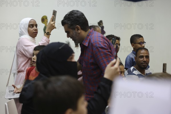 A Syrian puppeteer entertains children at the Damascus International Fair by imitating the role of the Hakawati, a traditional storyteller, while using hand puppets. The performance reflects Syria's cultural heritage and was part of activities organized for young visitors, Damascus, Damascus, Syria