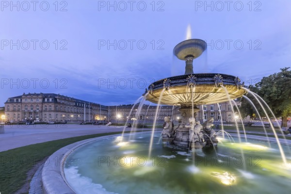Evening atmosphere at Schlossplatz Stuttgart. View of the New Palace. Illuminated fountain bowl at the fountain. Stuttgart, Baden-Württemberg, Germany