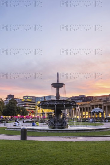 Evening atmosphere at Schlossplatz Stuttgart. View of Königstraße, art museum and Königsbau. Striking fountain with fountain bowl. Stuttgart, Baden-Württemberg, Germany