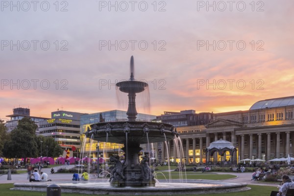 Evening atmosphere at Schlossplatz Stuttgart. View of Königstraße, art museum and Königsbau. Striking fountain with fountain bowl. Stuttgart, Baden-Württemberg, Germany