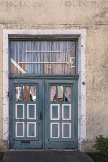 Blue wooden door with windows and white curtains on a rustic building, Old Town Burgsteinfurt, Steinfurt, Münsterland, North Rhine-Westphalia, Germany