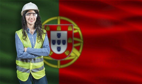 Portrait of smiling female engineer with Portuguese flag in background. Young female construction engineer with Portugal flag