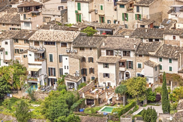 View at old idyllic residential houses with lush green gardens on an old village from an aerial view, Sóller, Mallorca, Spain