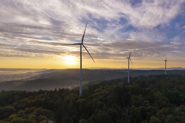 Wind turbines over a densely wooded area under a bright, clear morning sky, near Schorndorf, Rems-Murr district, Rems-Murr-Kreis, Baden-Württemberg, Germany