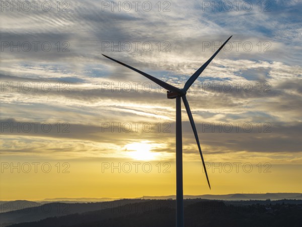A single wind turbine stands majestically against a breathtaking sky at sunrise, near Schorndorf, Remstal, Rems-Murr-Kreis, Baden-Württemberg, Germany