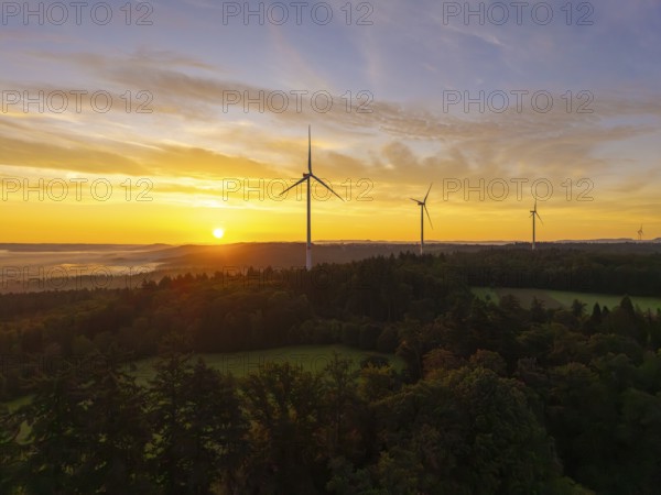 Wind turbines in a hilly and wooded landscape, illuminated by the rising sun, near Schorndorf, Remstal, Rems-Murr-Kreis, Baden-Württemberg, Germany