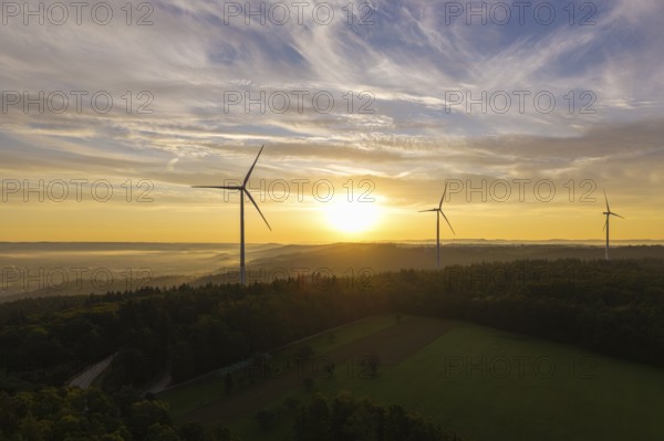 Wind turbines stretch across fields in the gentle sunlight that creates a peaceful horizon, near Schorndorf, Rems-Murr-Kreis, Rems-Murr Valley, Baden-Württemberg, Germany