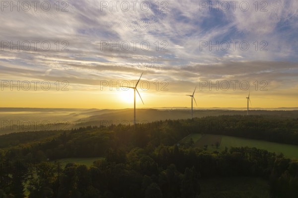 Three wind turbines above a hilly landscape, morning clouds reflecting the rising sunlight, near Schorndorf, Rems-Murr district, Rems-Murr-Kreis, Baden-Württemberg, Germany