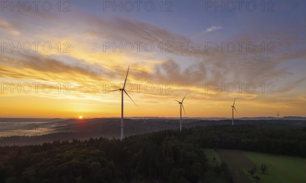 Three wind turbines at sunrise over a misty and golden landscape, near Schorndorf, Remstal, Rems-Murr-Kreis, Baden-Württemberg, Germany