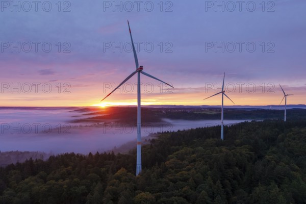 Wind turbines on a hill with sunlight breaking through the fog, sunrise, near Schorndorf, Remstal, Rems-Murr-Kreis, Baden-Württemberg, Germany