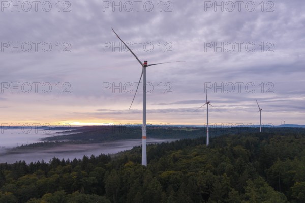 Three wind turbines above a forest at dusk under a cloudy sky, near Schorndorf, Rems-Murr district, Rems-Murr-Kreis, Baden-Württemberg, Germany