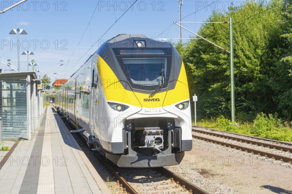 Frontal view of a train on the track next to the platform and green nature, battery Electric train with green electricity, Siemens Mireo Plus B, Freudenstadt, Germany