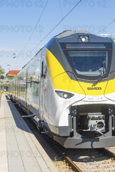 Modern white and yellow train on the track in sunny weather, taken from the side, battery Electric train with green electricity, Siemens Mireo Plus B, Freudenstadt, Germany