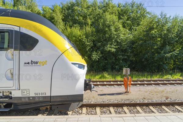 Train next to green vegetation and tracks on a sunny platform, battery Electric train with green electricity, Siemens Mireo Plus B, Freudenstadt, Germany