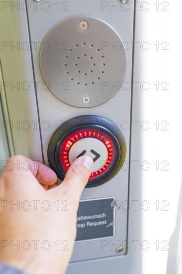 Close-up of a hand pressing a red illuminated stop button, battery Electric train with green electricity, Siemens Mireo Plus B, Freudenstadt, Germany