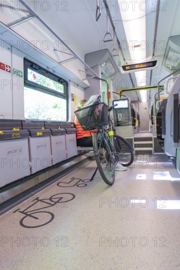 A modern designed train area for bicycles with seated cyclist, battery Electric train with green electricity, Siemens Mireo Plus B, Freudenstadt, Germany