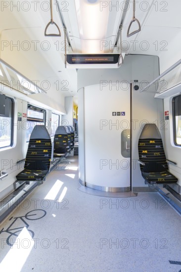 Modern and clean interior of a train with blue rows of seats and lots of light, battery Electric train with green electricity, Siemens Mireo Plus B, Freudenstadt, Germany